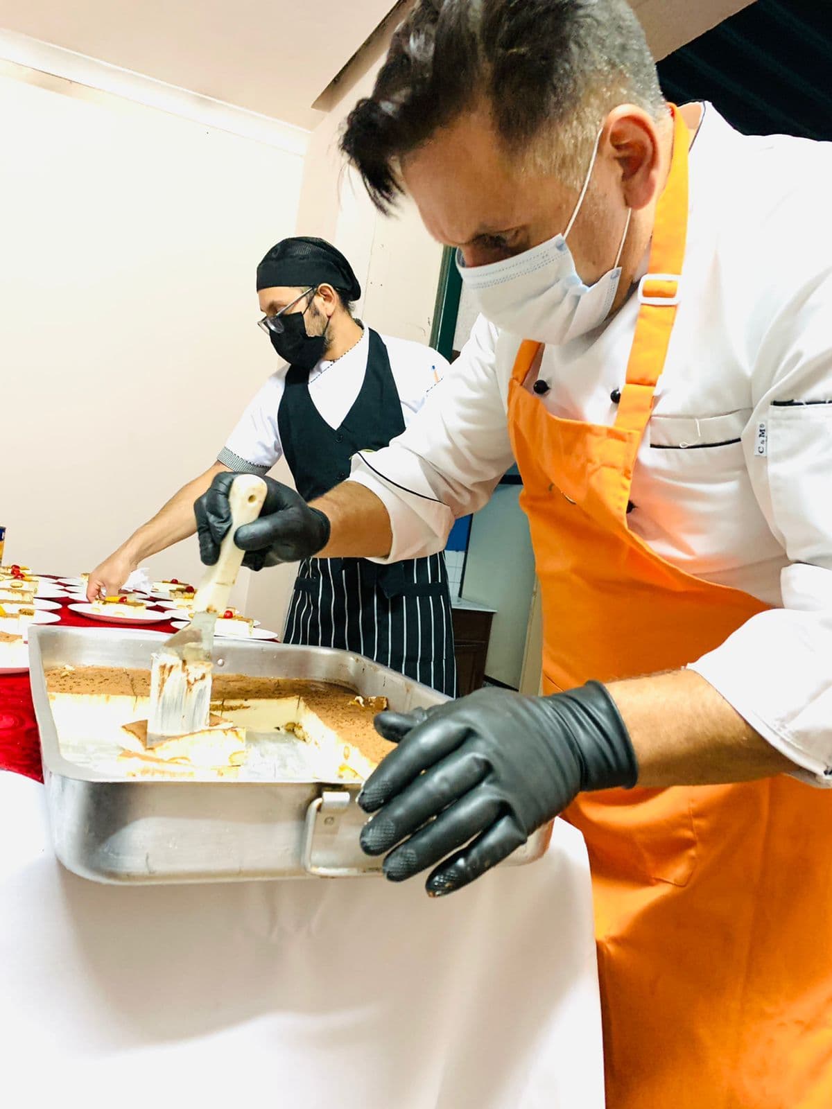 Chefs de Tomillo & Laurel con mascarilla y guantes preparando bandejas