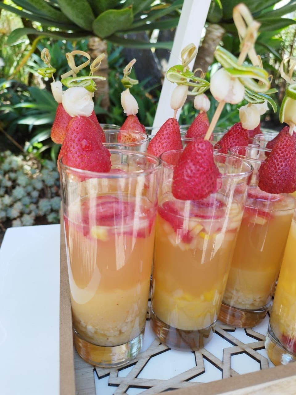 Vasos de fruta con brochetas de fresa